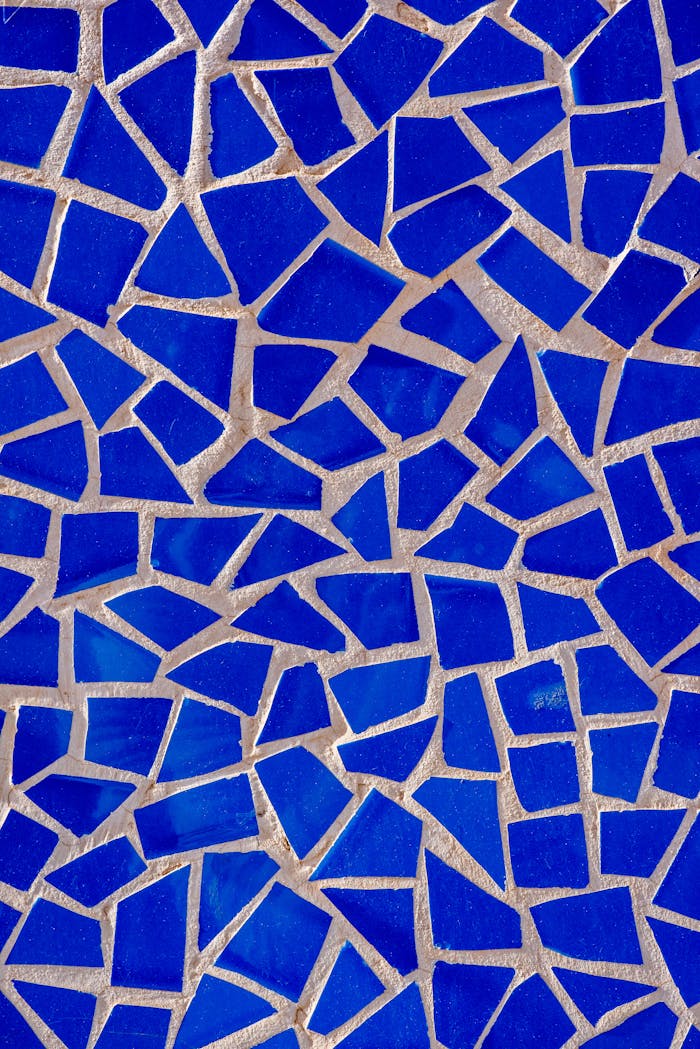 Vivid blue mosaic tile pattern creating an abstract artistic texture with geometric shapes.